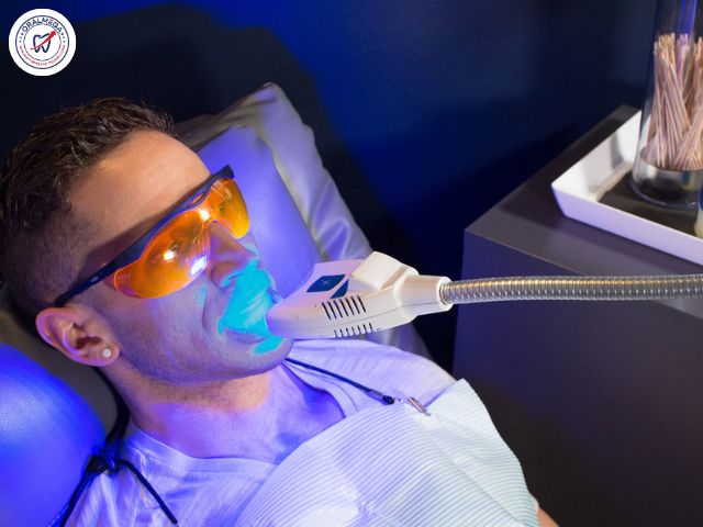 Man undergoing teeth whitening with blue light.